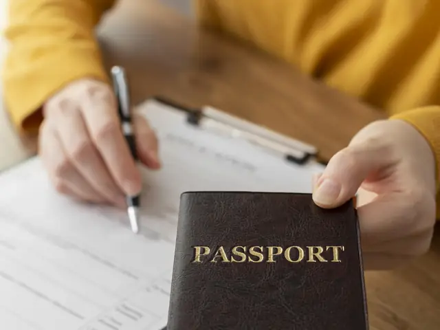 Persona diligenciando una solicitud de visa con su pasaporte